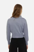 Back view of a person wearing a light blue knit sweater with a cropped hem and black jeans