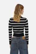 Back view of a woman in a navy and white striped cropped sweater and blue jeans.