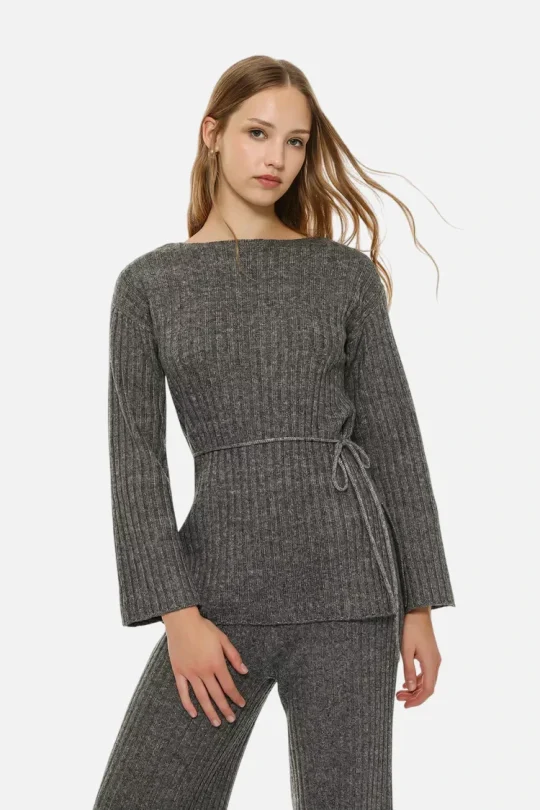 Grey ribbed knit knitwear set: boat-neck sweater with wrap tie at the waist and matching wide-leg pants, worn by a model